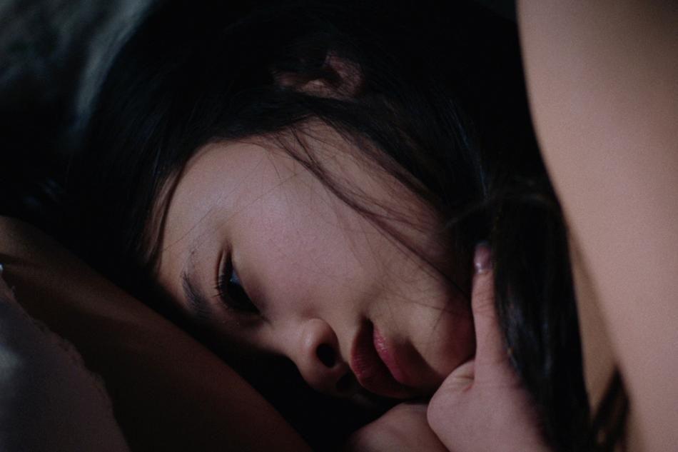 Still from "Copy, Save" depicting a young girl laying down.