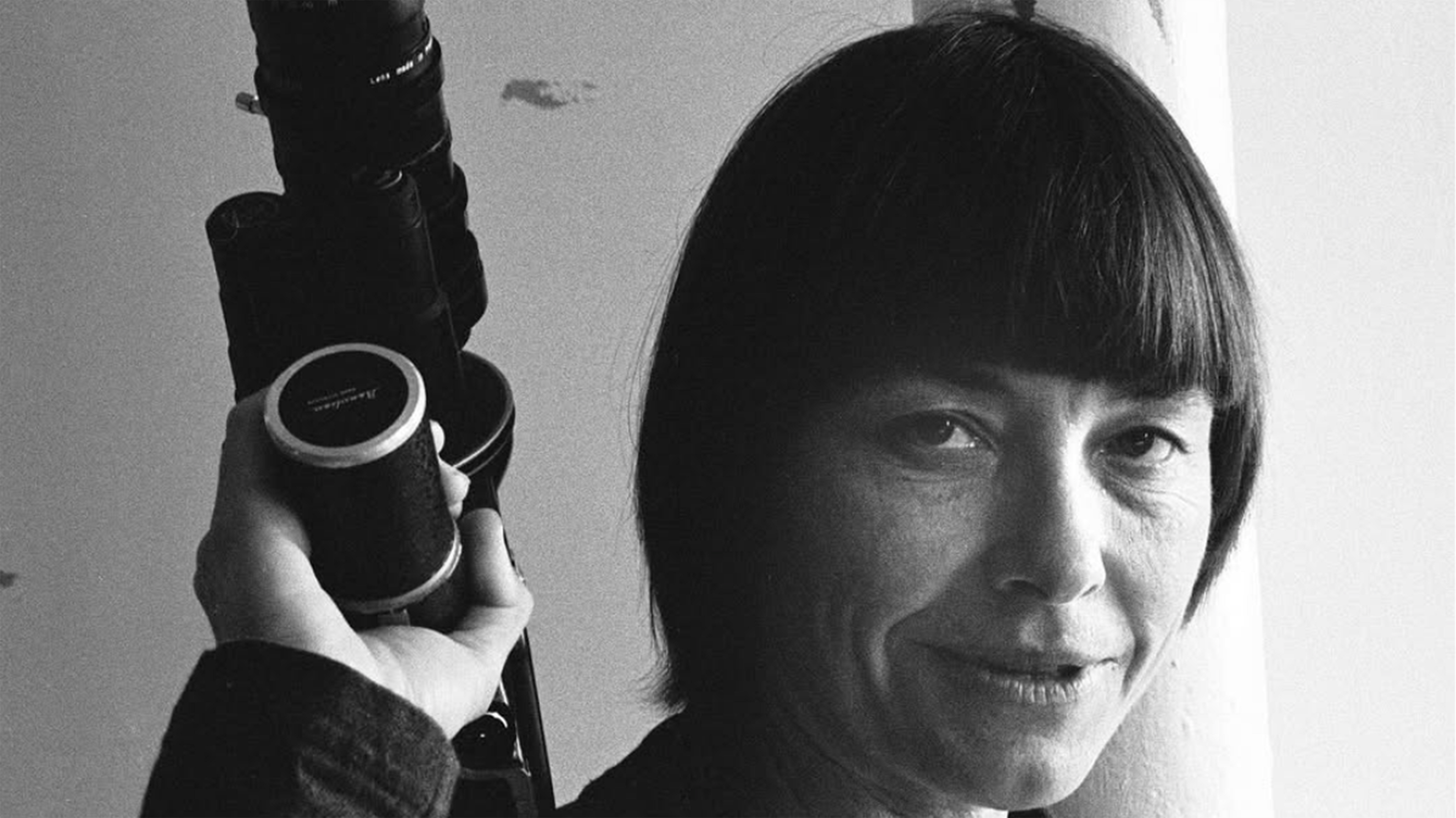 Barbara Hammer holding a film camera.