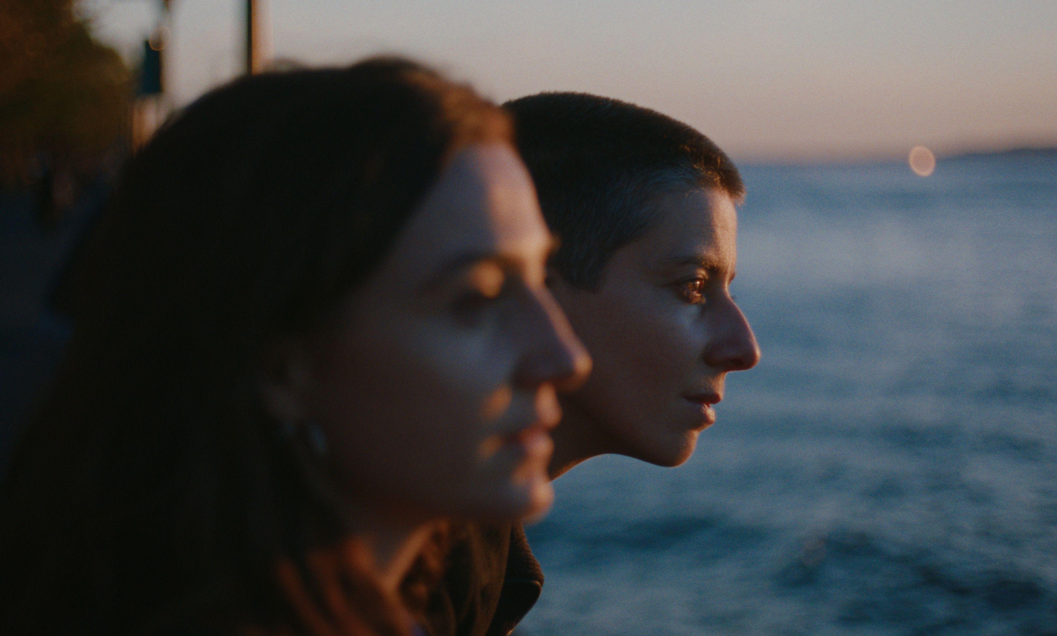Still from "Julian" depicting two people looking out onto the water at sunset.